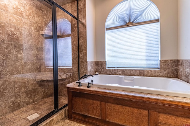 bathroom featuring shower with separate bathtub and a healthy amount of sunlight