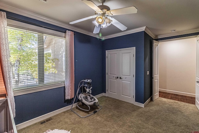 unfurnished bedroom with ornamental molding, a closet, carpet, and ceiling fan