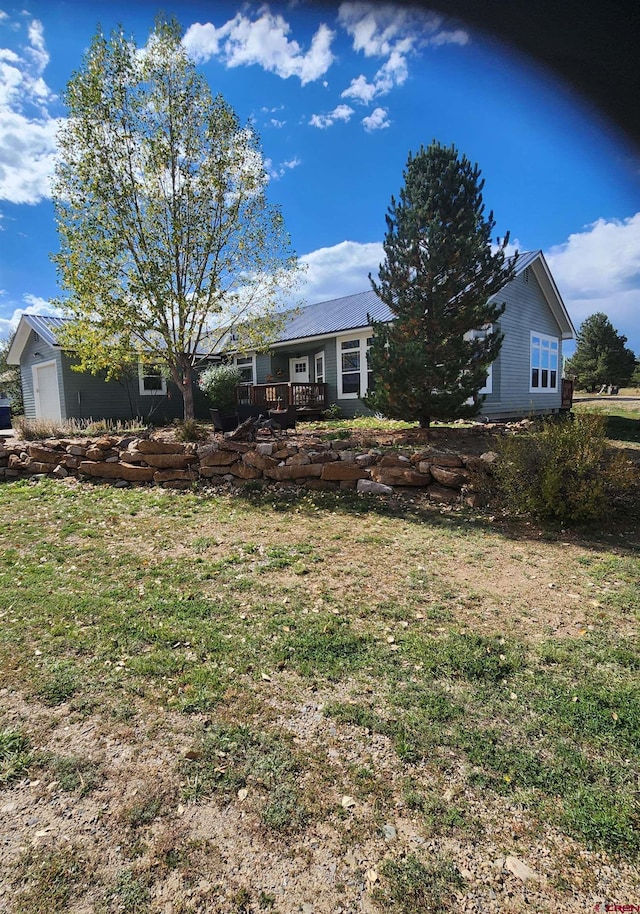 view of front of property with a deck and a front lawn