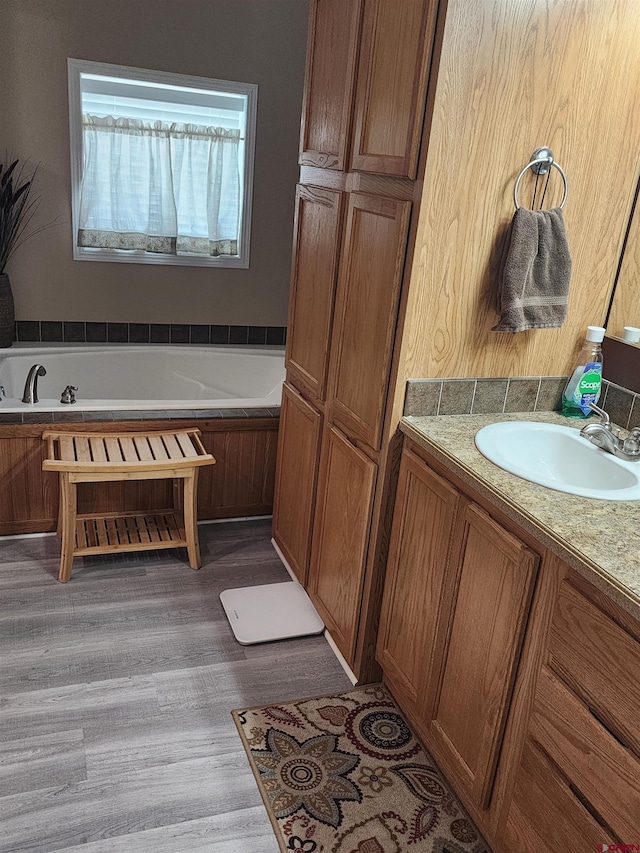 145 Lassen Dr, Pagosa Springs, CO 81147 - bathroom featuring vanity, hardwood / wood-style floors, and a washtub