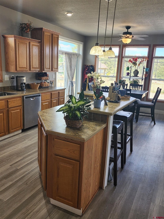 145 Lassen Dr, Pagosa Springs, CO 81147 - kitchen featuring hanging light fixtures, a textured ceiling, dishwasher, dark hardwood / wood-style floors, and a center island