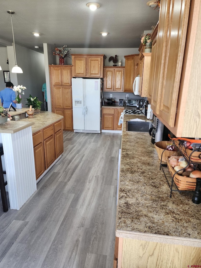 145 Lassen Dr, Pagosa Springs, CO 81147 - kitchen featuring pendant lighting, white appliances, and light hardwood / wood-style flooring