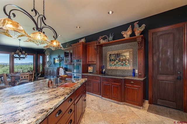 kitchen with pendant lighting, light stone counters, a chandelier, sink, and stainless steel double oven