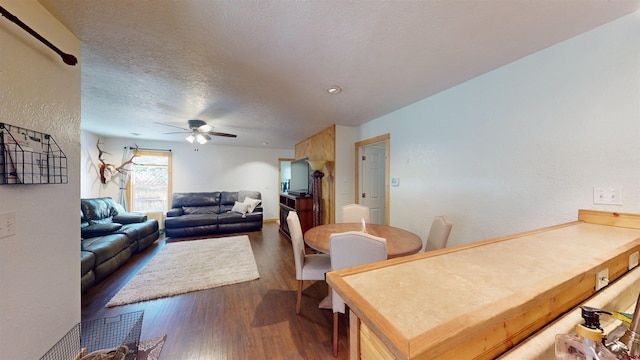 dining space with a textured ceiling, dark hardwood / wood-style floors, and ceiling fan