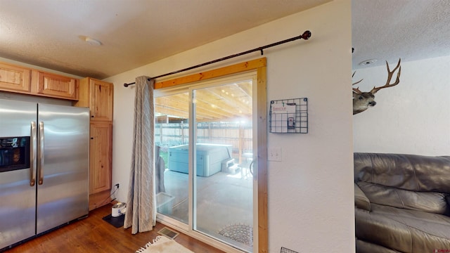 doorway with a textured ceiling and dark hardwood / wood-style flooring