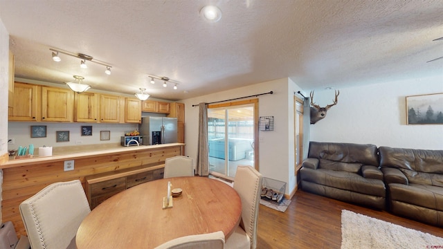 kitchen featuring rail lighting, a textured ceiling, light brown cabinetry, dark hardwood / wood-style floors, and stainless steel fridge with ice dispenser