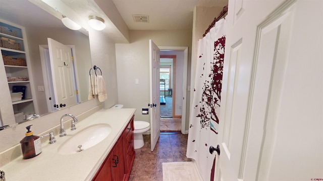 bathroom with vanity, tile patterned flooring, and toilet