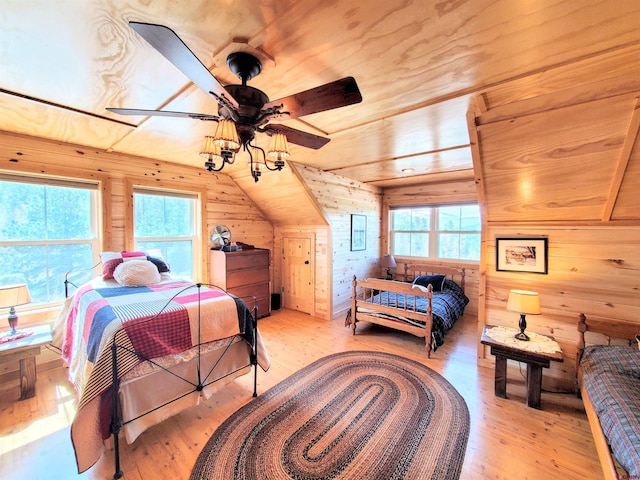 bedroom with multiple windows, vaulted ceiling, ceiling fan, and light hardwood / wood-style flooring