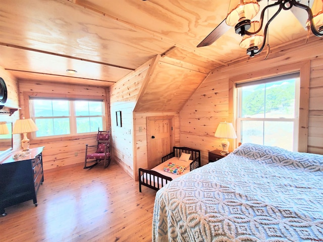 bedroom with ceiling fan, lofted ceiling, multiple windows, and hardwood / wood-style floors