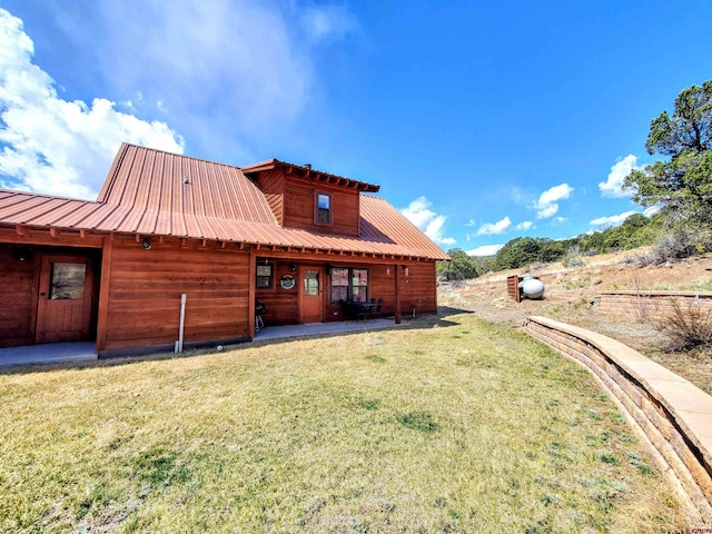 back of house featuring a patio and a yard