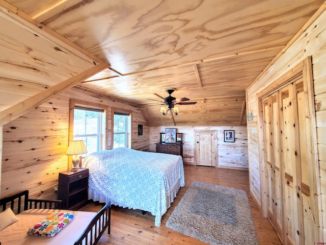 bedroom with ceiling fan, wooden walls, hardwood / wood-style flooring, wooden ceiling, and vaulted ceiling