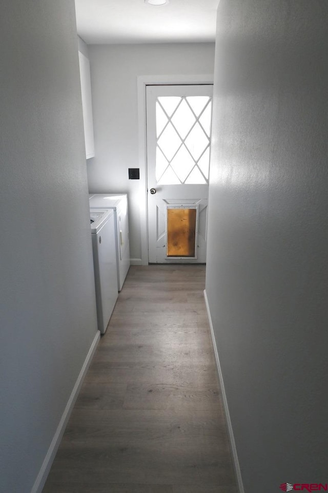 clothes washing area featuring wood-type flooring and washer and dryer