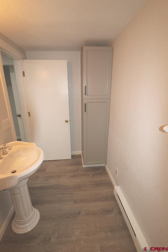 bathroom featuring hardwood / wood-style flooring and a baseboard heating unit