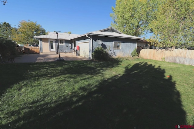 back of house featuring a lawn and a patio area