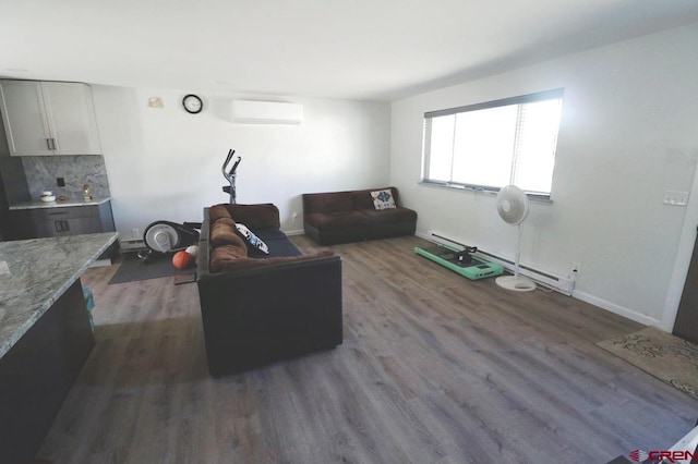 living room featuring dark hardwood / wood-style flooring, a baseboard heating unit, and a wall mounted air conditioner