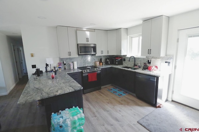 kitchen with a healthy amount of sunlight, white cabinetry, and electric stove