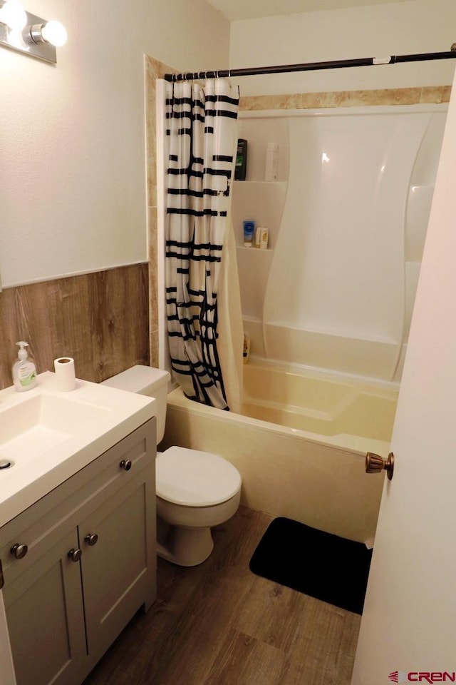 full bathroom featuring hardwood / wood-style floors, vanity, shower / tub combo, and toilet