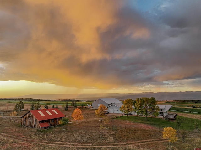 view of home's community featuring a mountain view, a rural view, and an outbuilding