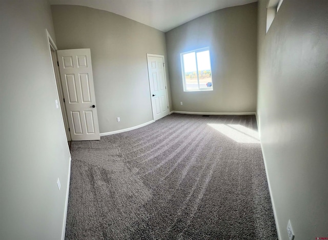 spare room featuring vaulted ceiling and carpet floors