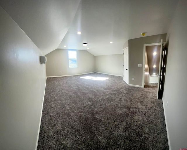 bonus room featuring dark carpet and vaulted ceiling