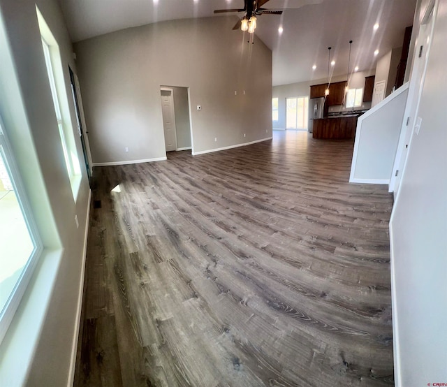 unfurnished living room with high vaulted ceiling, wood-type flooring, and ceiling fan