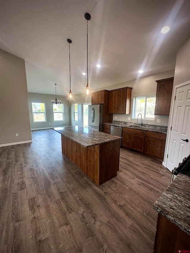 kitchen featuring appliances with stainless steel finishes, dark hardwood / wood-style flooring, a wealth of natural light, and a kitchen island