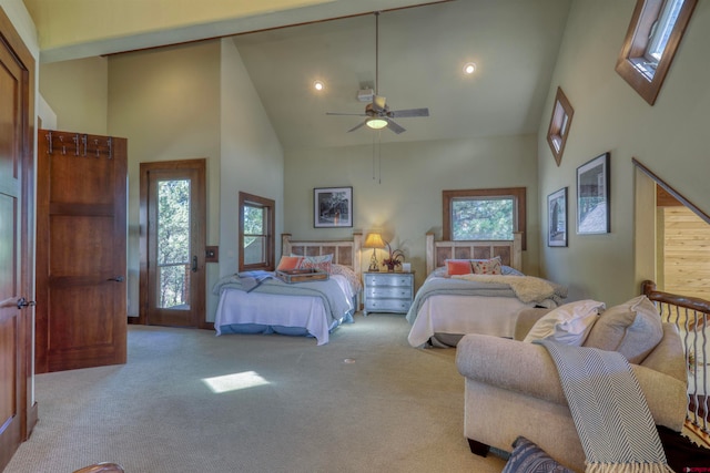 bedroom featuring ceiling fan, multiple windows, light carpet, and high vaulted ceiling