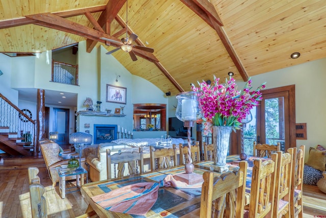 dining space featuring high vaulted ceiling, light hardwood / wood-style floors, beamed ceiling, and ceiling fan