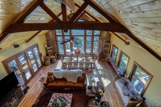 unfurnished living room with high vaulted ceiling, wood-type flooring, beamed ceiling, and wood ceiling