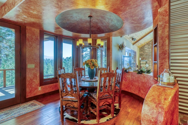 dining room with an inviting chandelier, plenty of natural light, and hardwood / wood-style floors