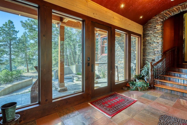 doorway to outside featuring vaulted ceiling