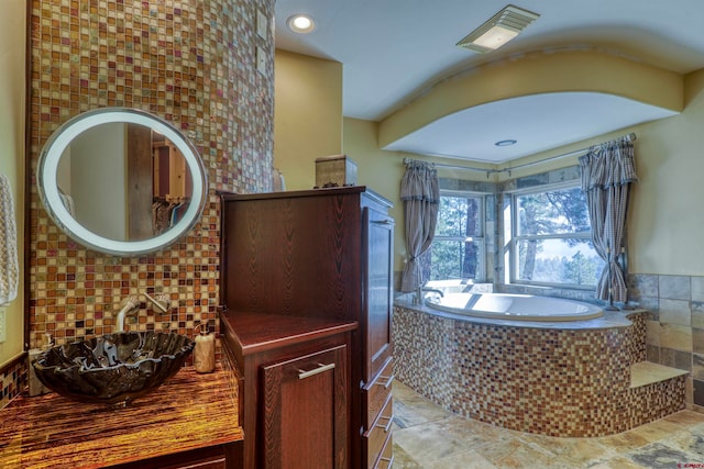 bathroom featuring a tub to relax in, tile patterned flooring, and sink