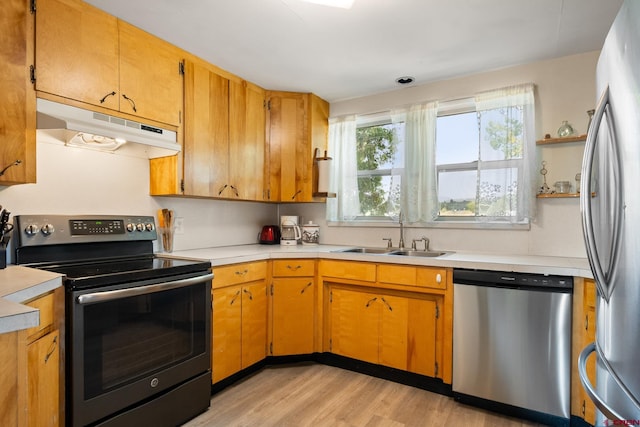 kitchen featuring appliances with stainless steel finishes, light wood-type flooring, and sink