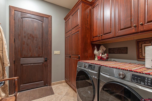 laundry room featuring cabinets, light tile patterned floors, and washer and clothes dryer