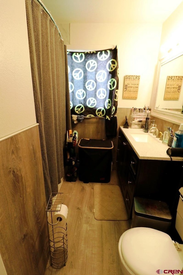 bathroom featuring walk in shower, vanity, toilet, and hardwood / wood-style flooring