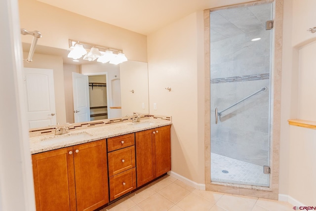 bathroom featuring tile patterned flooring, a shower with door, and vanity