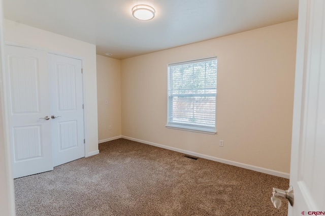 unfurnished bedroom featuring carpet and a closet