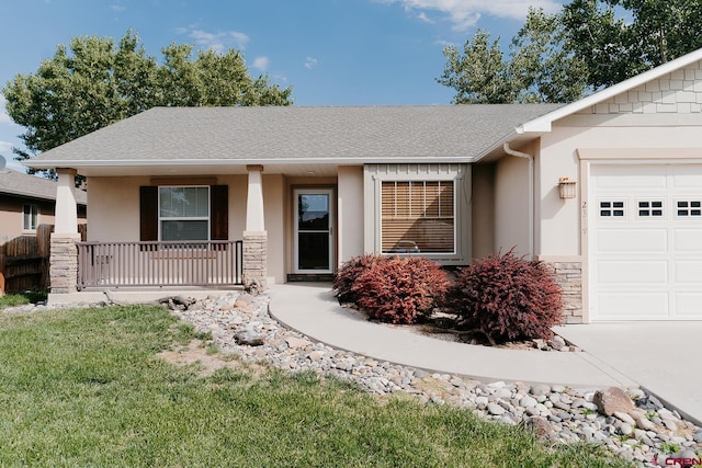 single story home with a garage, a front yard, and covered porch