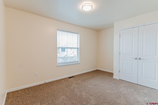 unfurnished bedroom with a closet and carpet floors