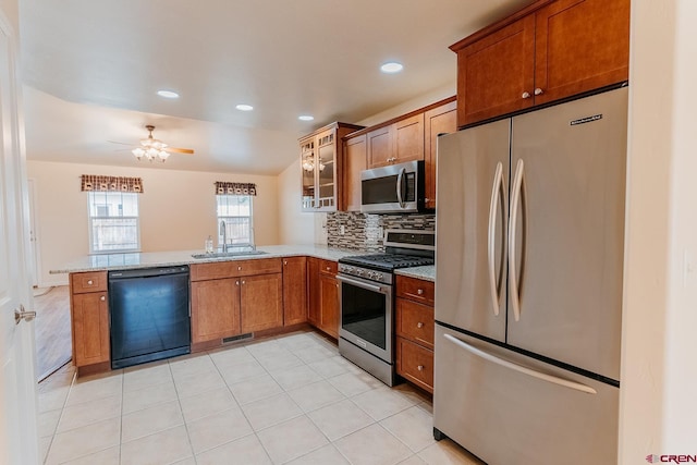 kitchen featuring appliances with stainless steel finishes, tasteful backsplash, kitchen peninsula, ceiling fan, and sink