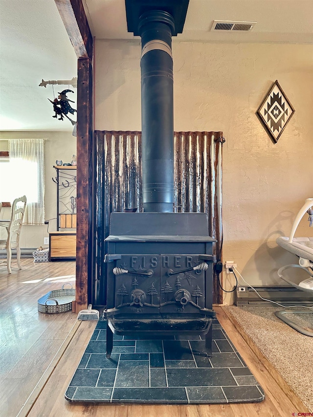 room details with a wood stove and wood-type flooring