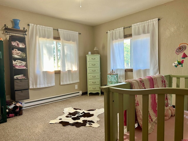 bedroom featuring carpet, a nursery area, and a baseboard radiator