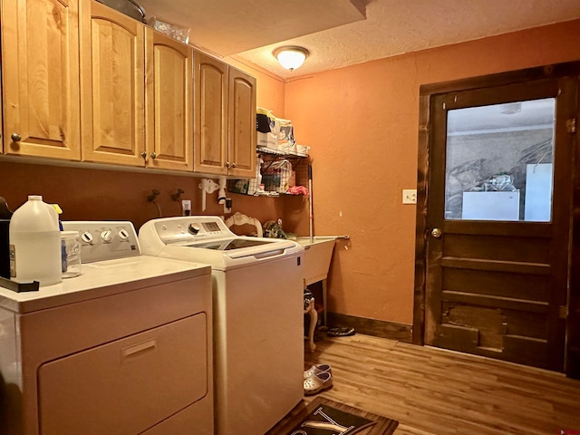 clothes washing area with wood-type flooring, cabinets, independent washer and dryer, and a textured ceiling