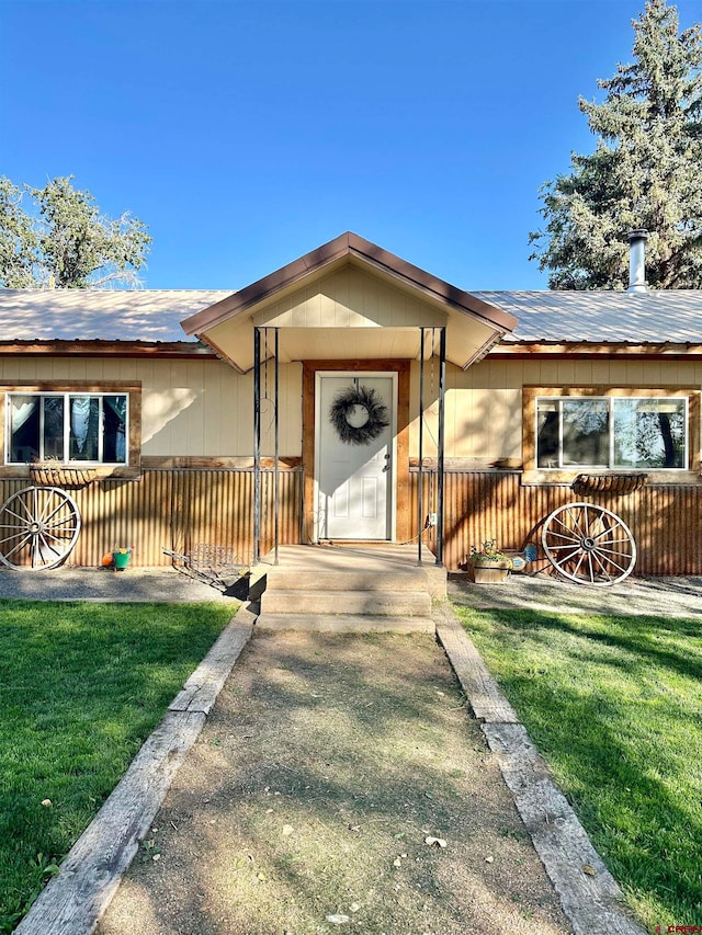 doorway to property with a lawn