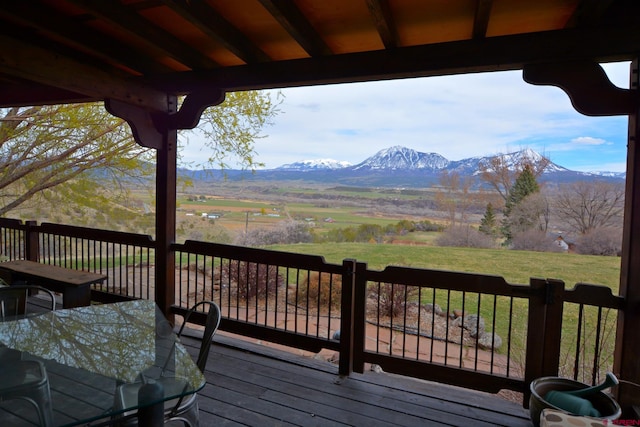 wooden terrace featuring a rural view and a mountain view