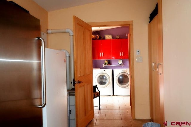 clothes washing area with washing machine and dryer and cabinets