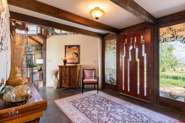 foyer entrance featuring dark tile patterned floors and beamed ceiling