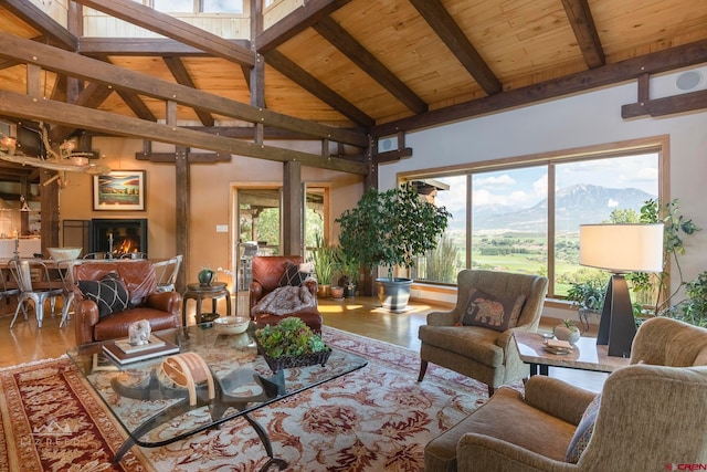 living room featuring a mountain view, beamed ceiling, wood ceiling, and high vaulted ceiling