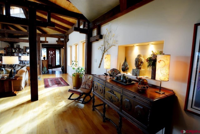 hallway featuring light wood-type flooring, beam ceiling, and high vaulted ceiling