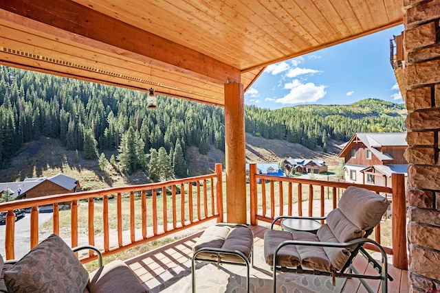 wooden terrace featuring a storage unit and a mountain view